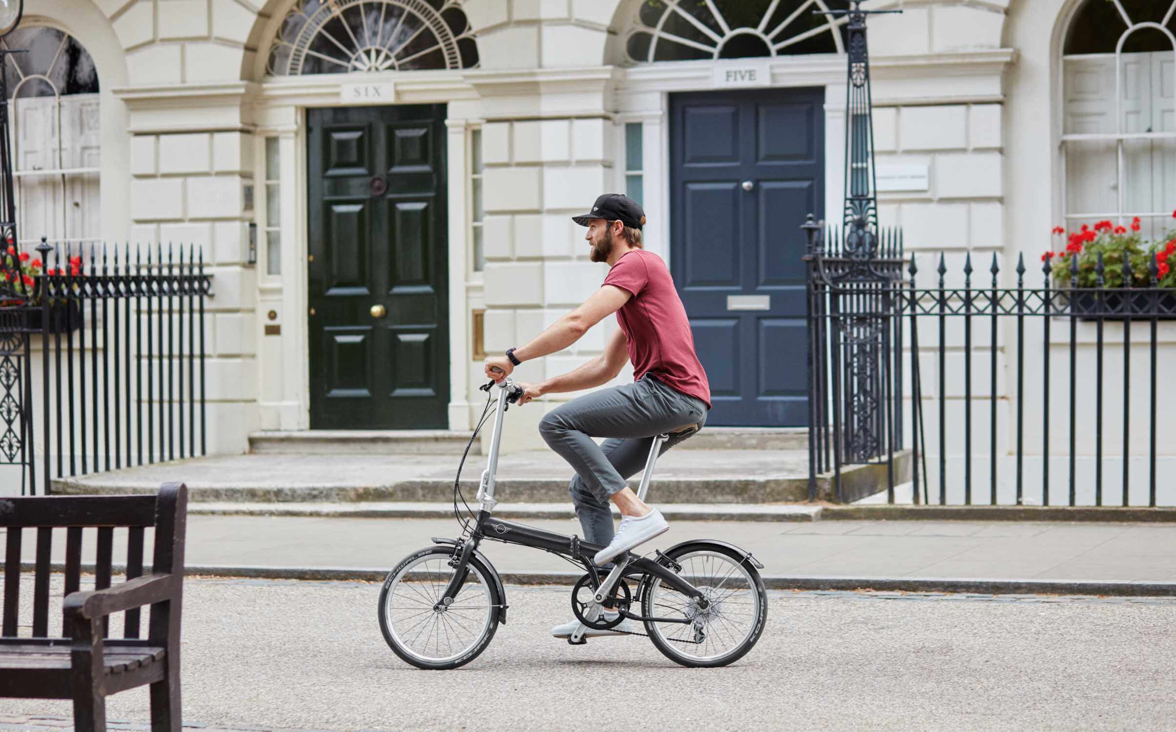 Seorang pria terlihat mengendarai sepeda lipat di dalam kota